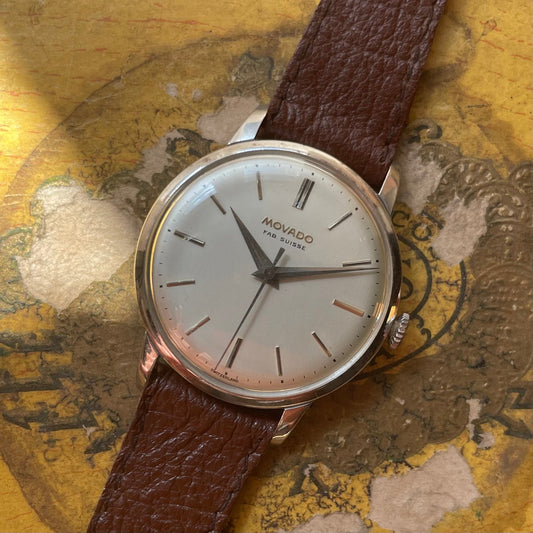 Reloj Vintage Movado desde la década de 1950 en acero chapado en oro gris con dial blanco y pulsera de cuero marrón